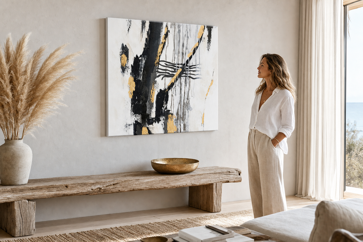 A modern, stílusos belső térben, egy fa konzol felett elhelyezett absztrakt festmény fekete, arany és fehér színekkel, váza és gyertya társaságában, Papilora.